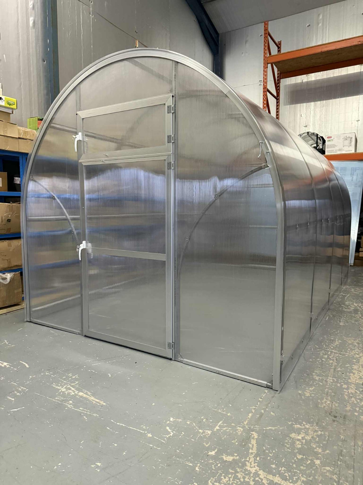 Metal Sigma 250 (Gen III) greenhouse structure in a warehouse setting - Planta Greenhouses EU.