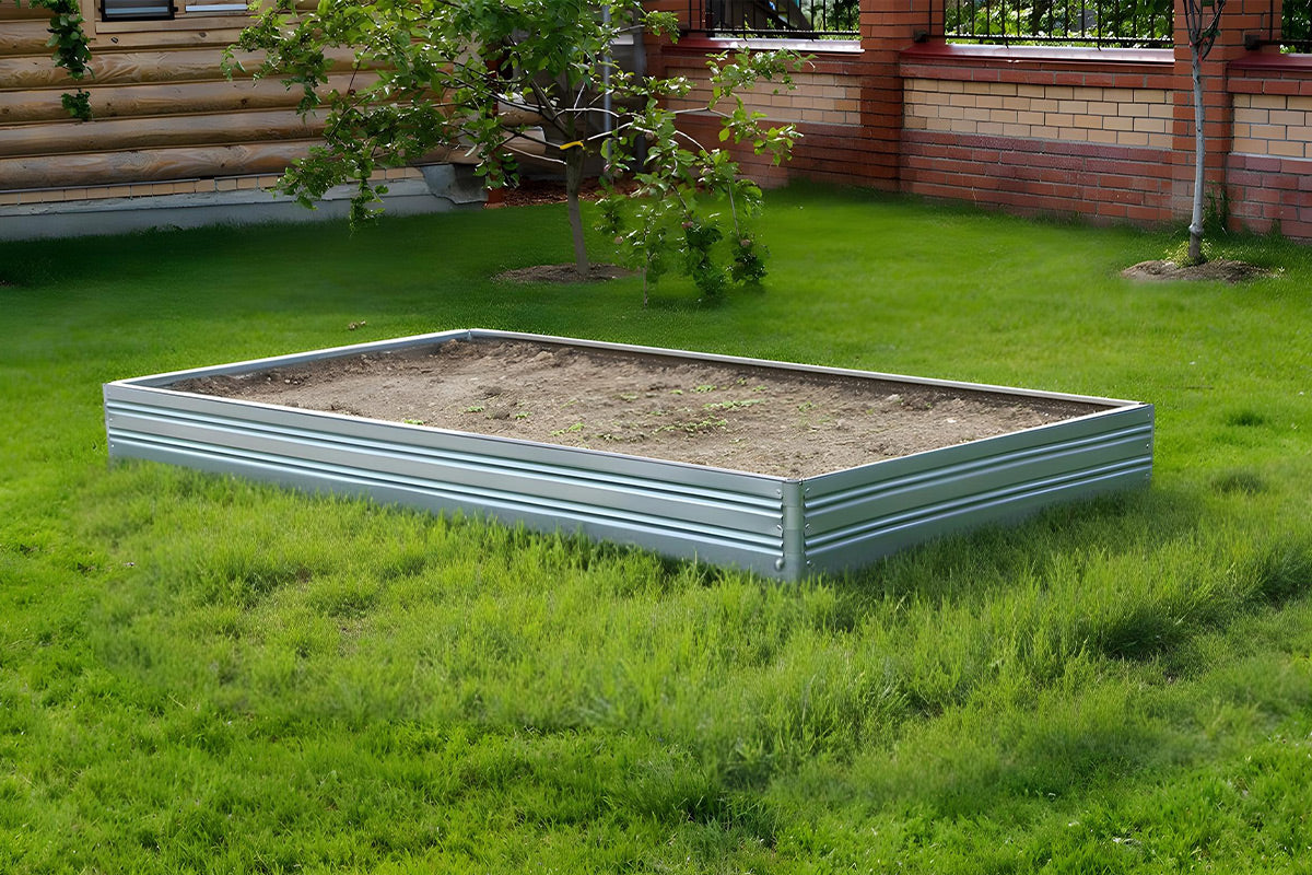 Metal raised Planta garden bed - 1 tier on grass with wooden fence and plants in the background