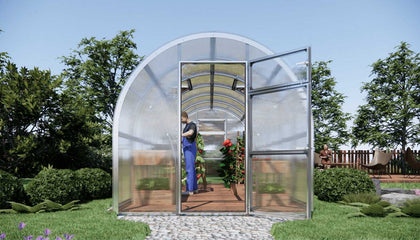 Arc-shaped Sigma 2.5x6 (Gen III) greenhouse with a person inside, surrounded by trees and greenery.